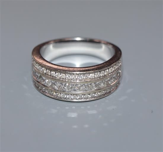 A modern 750 white metal and three row round and princess cut diamond half hoop ring, size O.